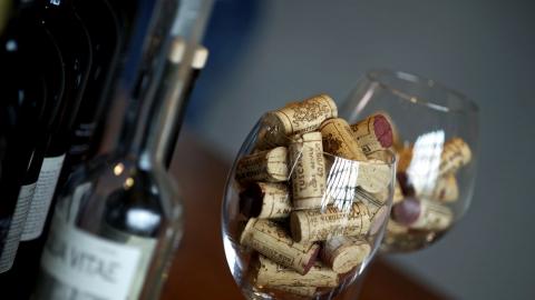 une bouteille de vin et un gobelet rempli de bouchons.